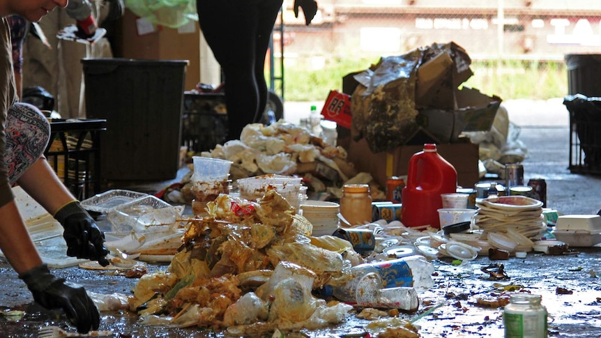 Piles of waste from a day at a Darwin market laid out on the floor, including food scraps and bin juice.