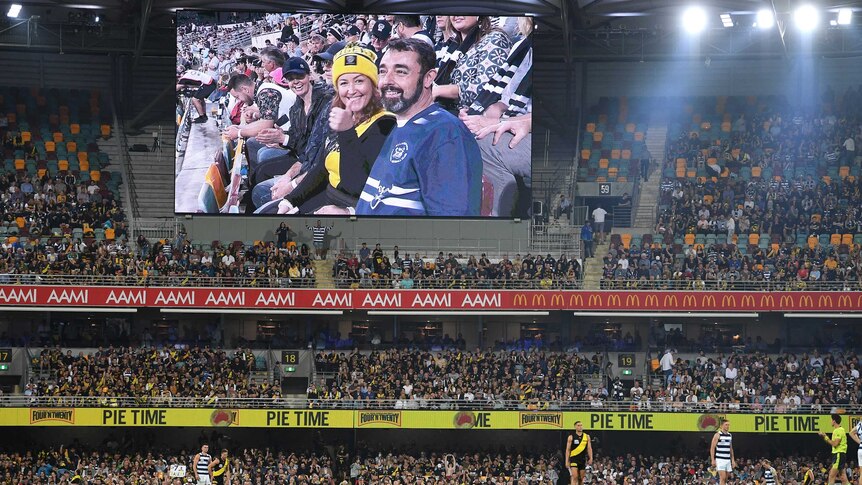 A view of a crowded grandstand and a big screen showing fans during the AFL grand final.