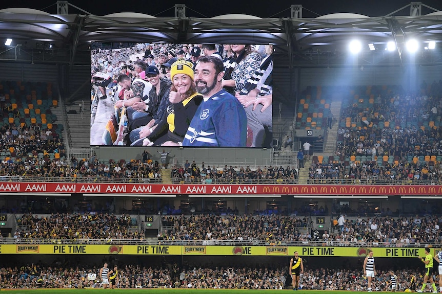 A view of a crowded grandstand and a big screen showing fans during the AFL grand final.