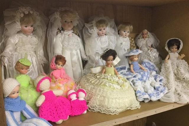 Dolls in bookcase, bridal and crocheted dolls