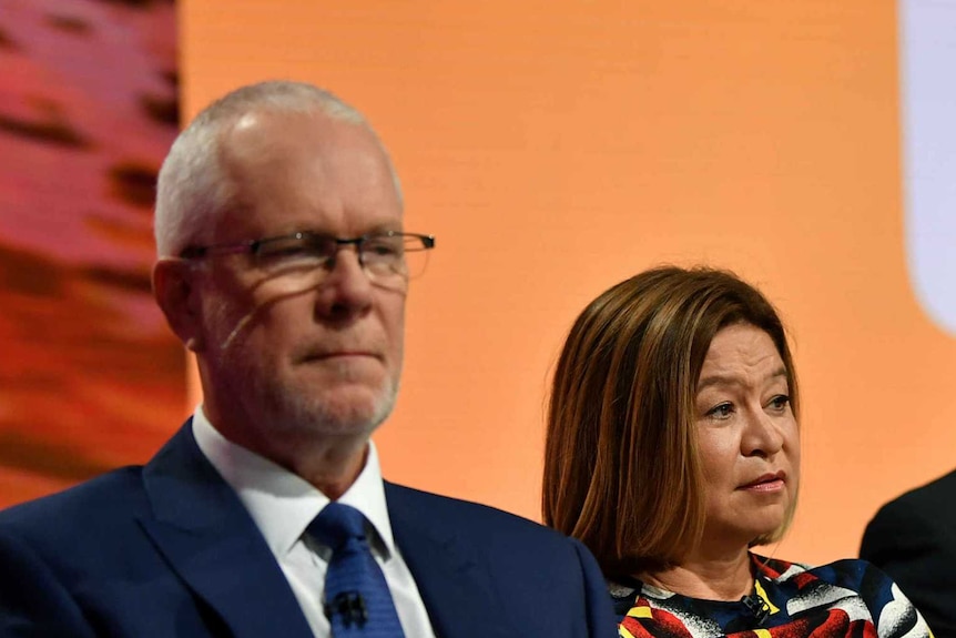 Four people sitting at the front of a studio.