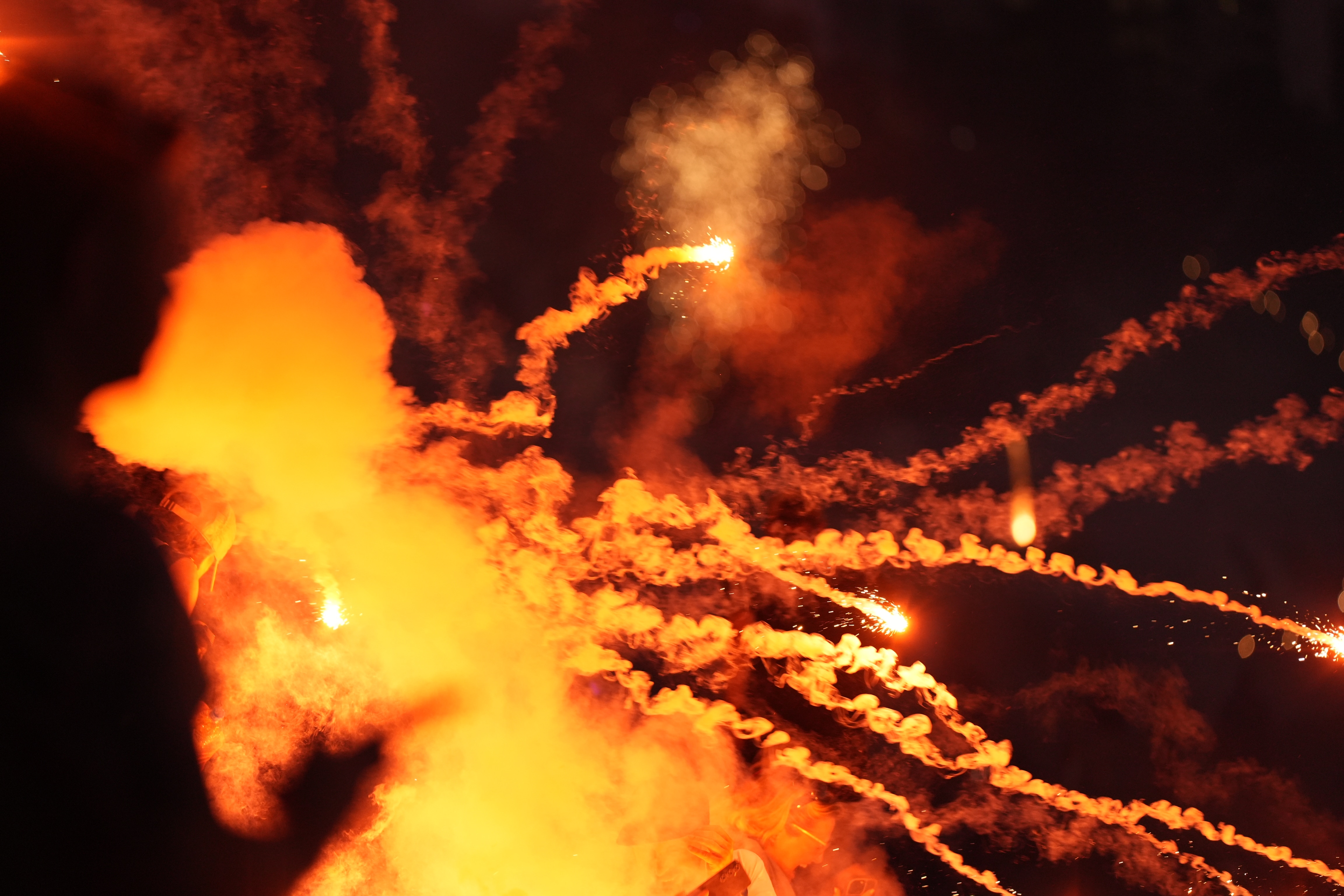 red smoke of fireworks with a bright red light at the centre on a black sky