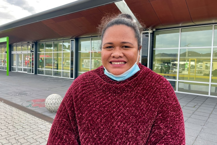 An islander woman stands in front of an airport