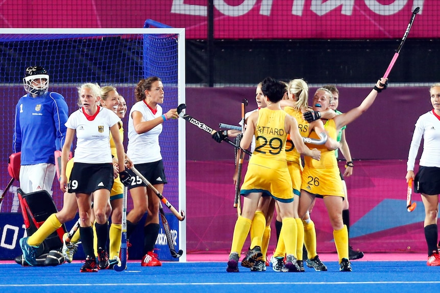 Emily Smith celebrates a goal with team-mates during Australia's hockey match against Germany.