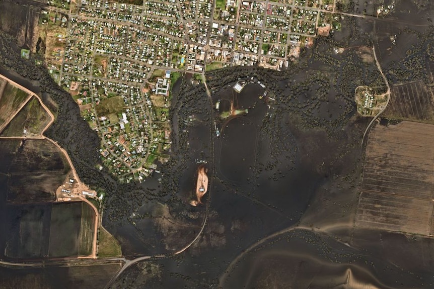 aerial view of black floodwaters outlining a small township