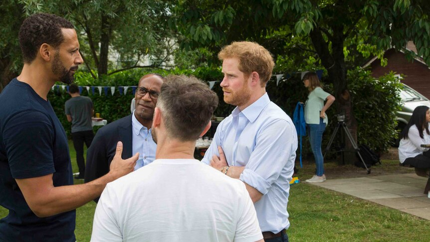 Prince Harry speaks to Rio Ferdinand at a Heads Together event.
