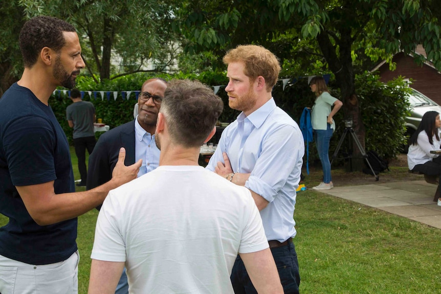 Prince Harry speaks to Rio Ferdinand at a Heads Together event.