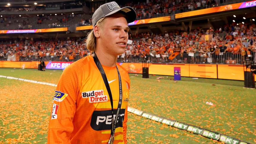 A Perth Scorchers BBL layer walking on the field with a BBL winners medal around his neck.