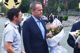 Opposition Leader Bill Shorten holding flowers outside Dreamworld