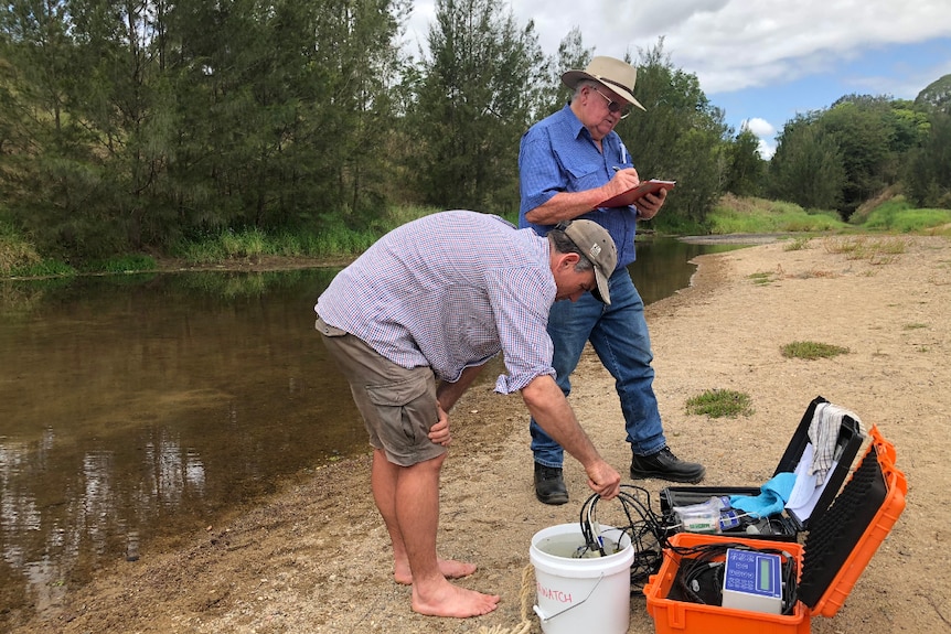 Brad Wedlock and a volunteer testing the river water.