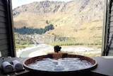 Priya in a large hot tub overlooking mountain scenery, in a story about divorce stigma.