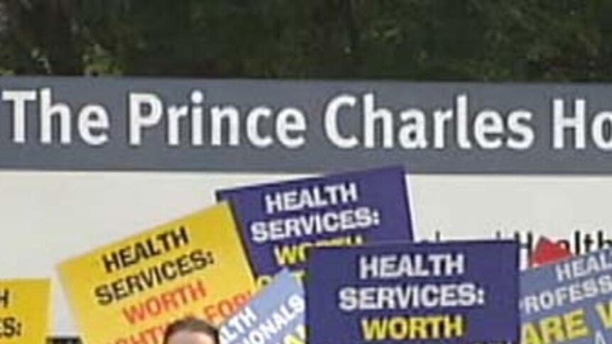 Striking allied health workers wave placards outside Brisbane's Prince Charles Hospital.
