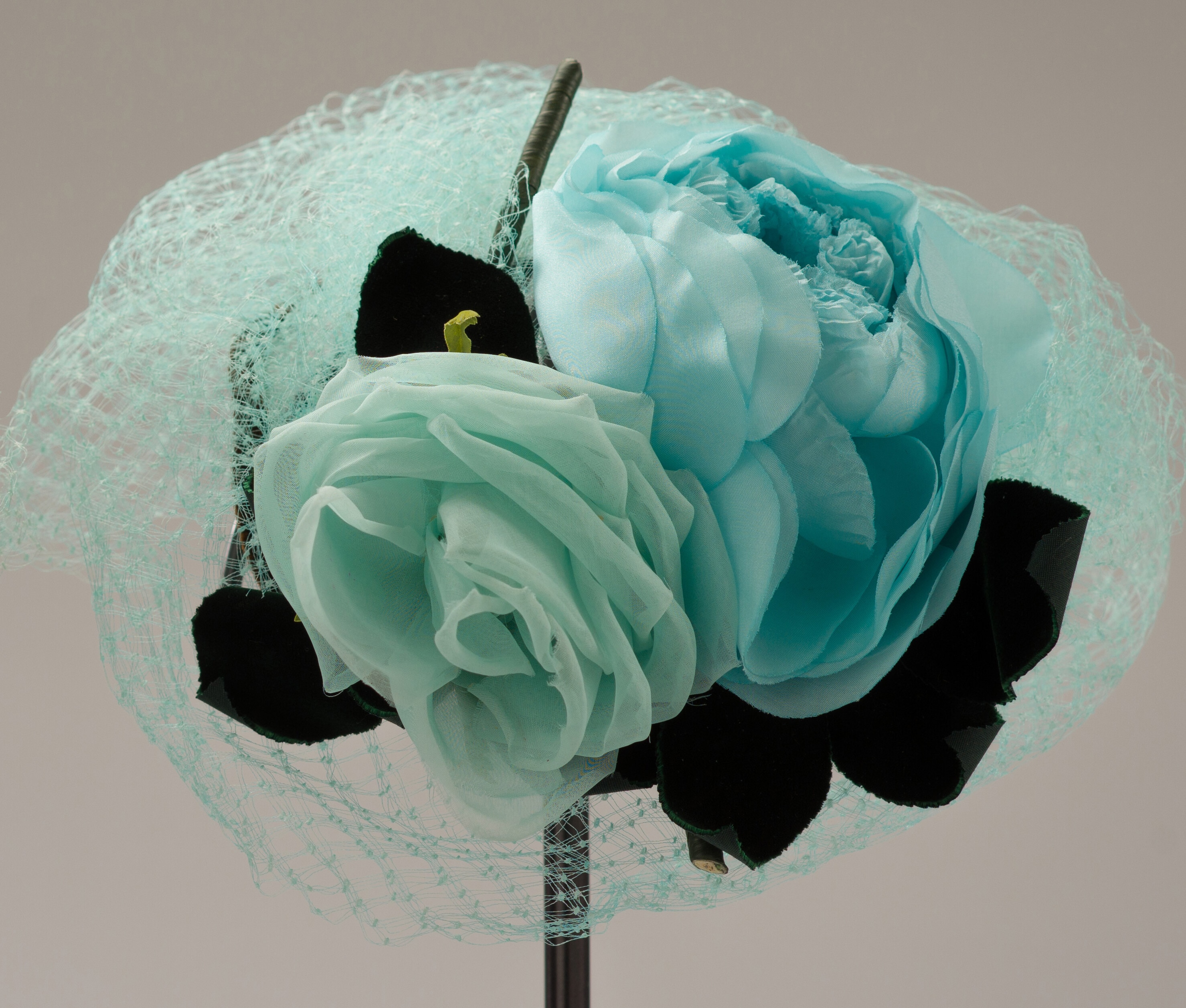 Turquoise hat with fabric flowers and tulle