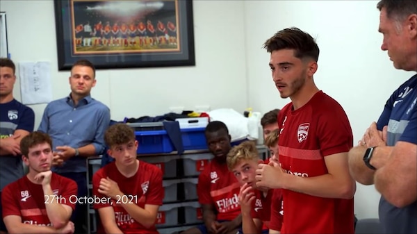Josh Cavallo speaks to Adelaide United teammates in a dressing room.