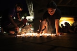 Attendees light candles at a vigil for Md Isfaqur Rahman.