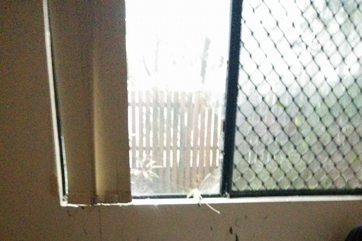 Bedroom windows are broken as a storm hits the Brisbane suburb of Annerley.