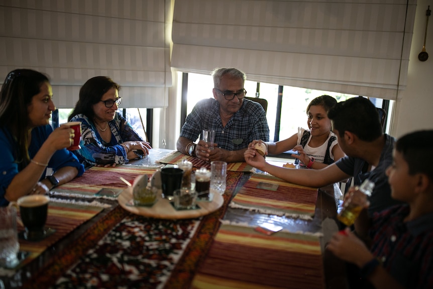 A family sitting around a dinner table.