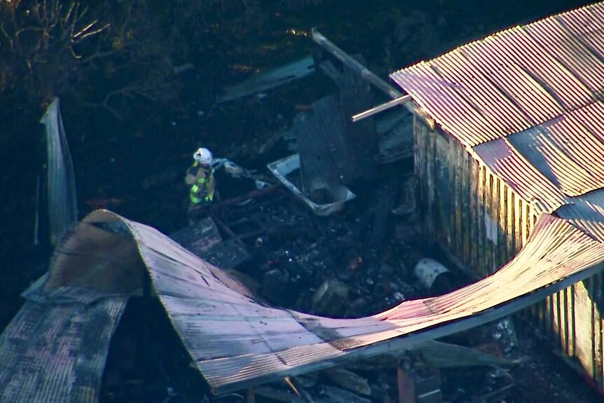 aerial photo of collapsed roof, fire damage, with firefighter