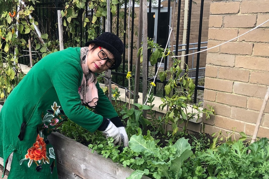 Alice Wang bends over her veggie patch.