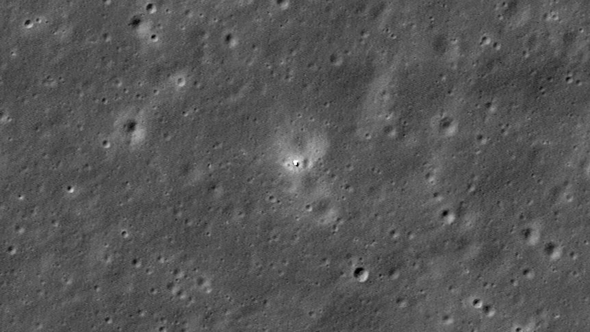 A satellite image of a tiny white dot surrounded by moon craters 