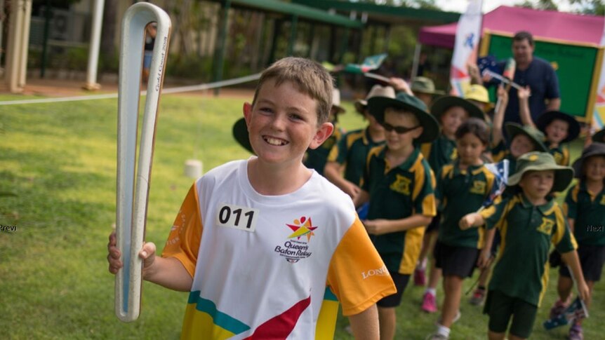 An 11-year-old boy carries the Queen's Baton ahead of the Commonwealth Games on the Gold Coast