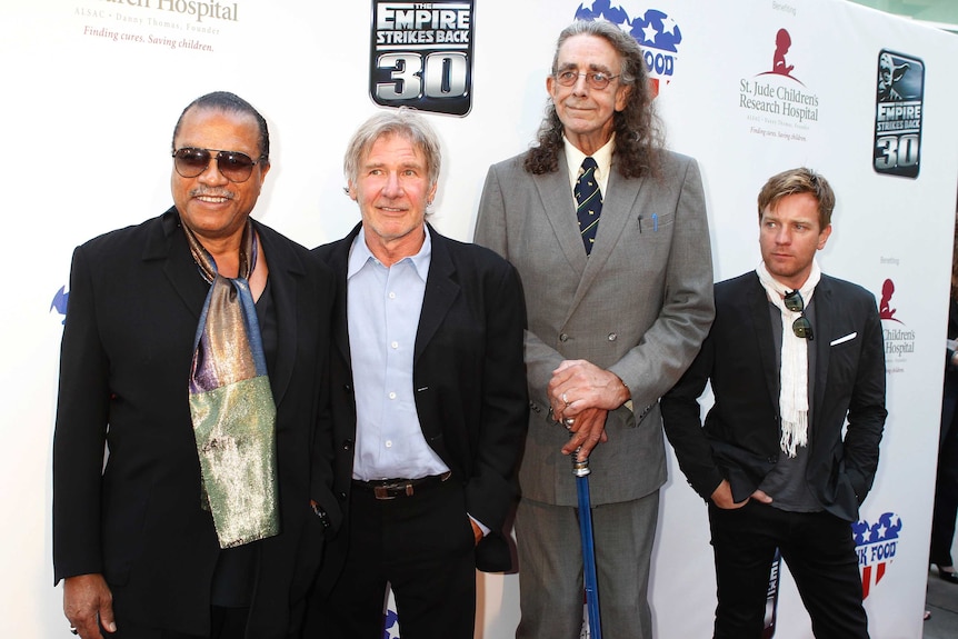 Four cast members pose on the red carpet at a film anniversary screening