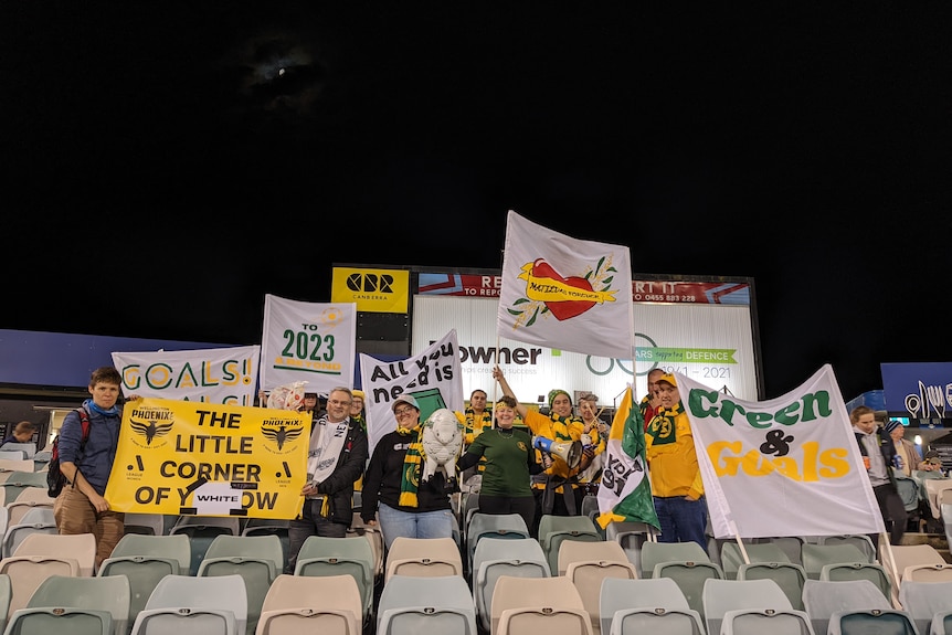 Matildas fans sit in the stands at Canberra Stadium with banners.