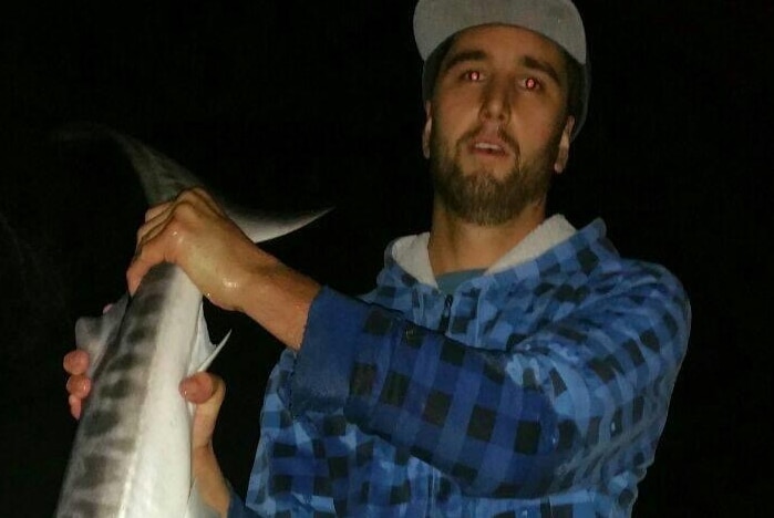 A man poses with a fish