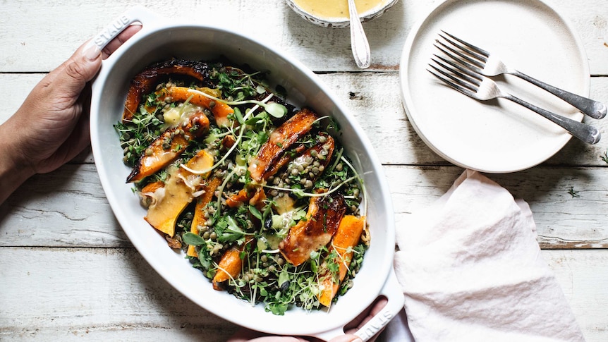 Roast pumpkin and lentil salad in a serving dish with a side of honey miso dressing, an easy recipe