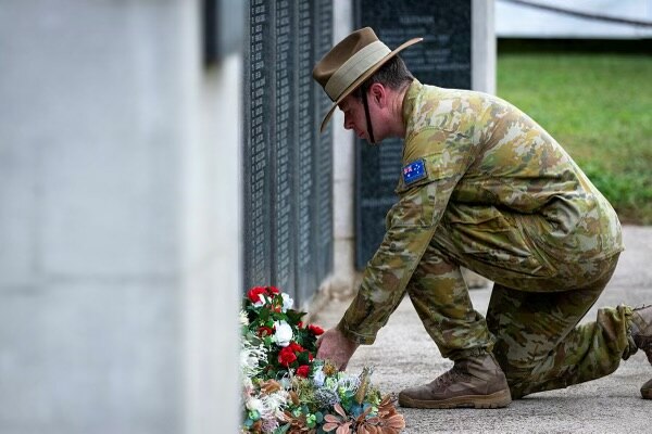 Soldier laying wreath at a memorial