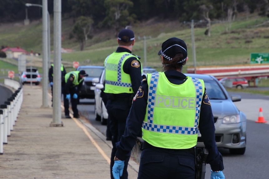 Police stop cars and talk to drivers at a coronavirus roadblock near Burnie