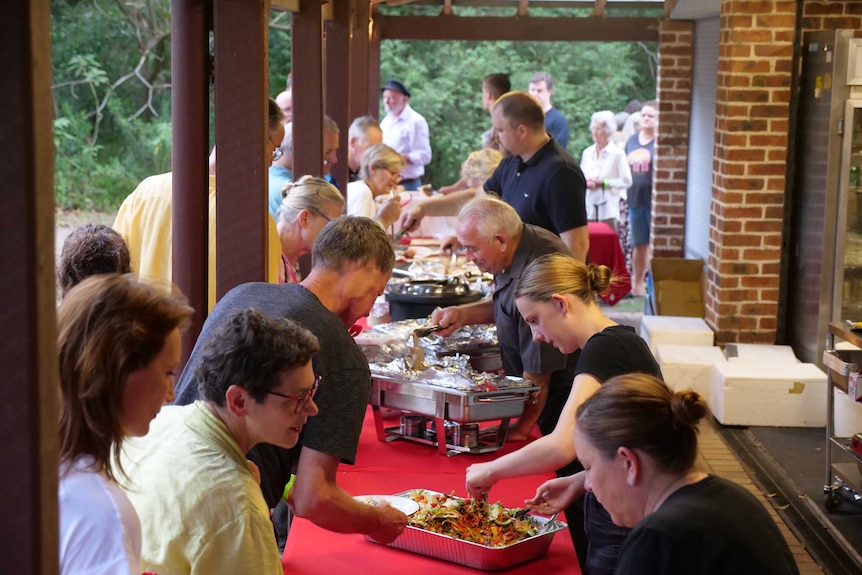 St Albans residents line up to be served food at the community party following the bushfires.