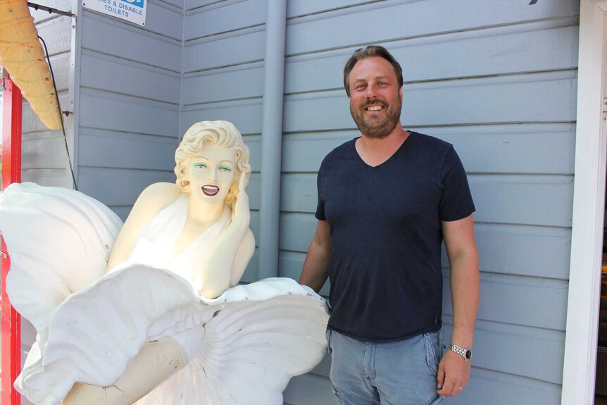 Oliver Cooke owner of Fredo's Pies standing with famous Marilyn Munroe statue.
