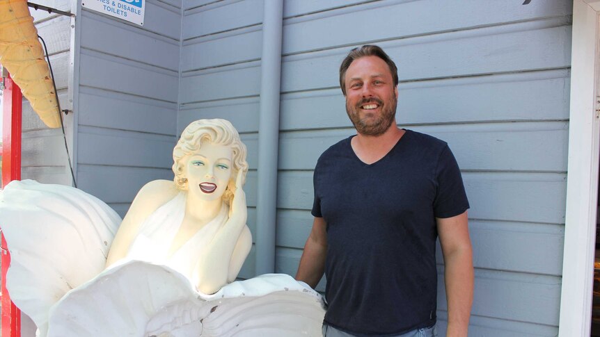 Oliver Cooke owner of Fredo's Pies standing with famous Marilyn Munroe statue.