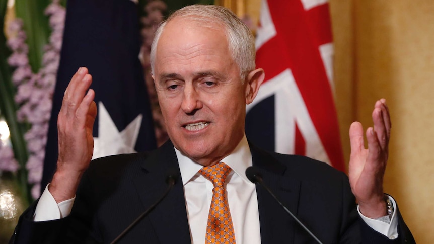 Prime Minister Malcolm Turnbull speaks with microphones in front of him, hands gesturing beside his face