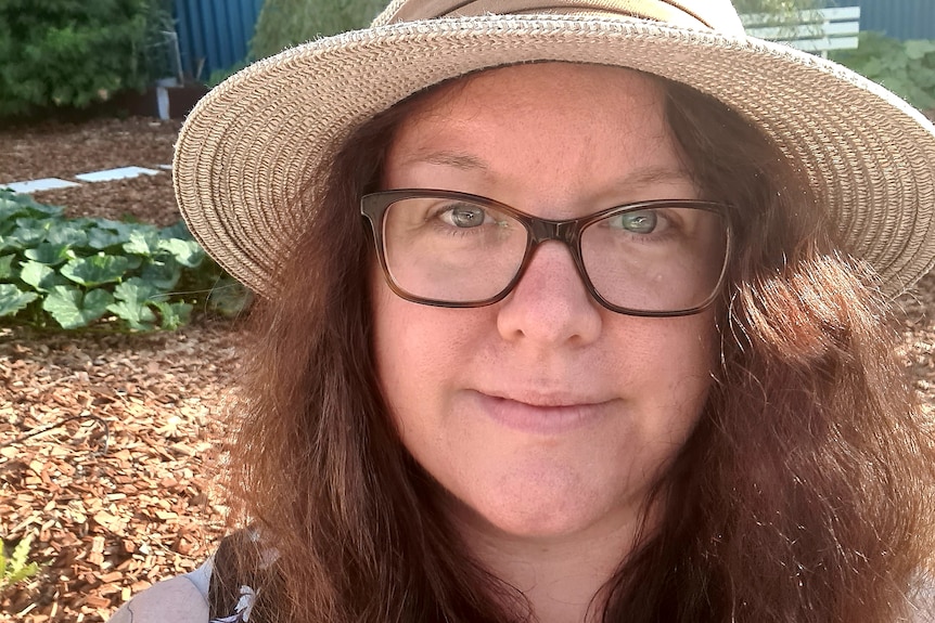 A lady in a hat smiles in a selfie 