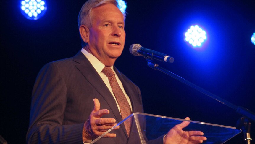 A mid shot of Colin Barnett talking into a microphone at a pedestal.