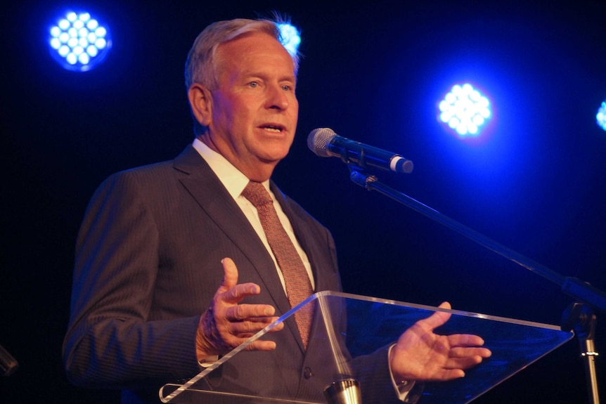 A mid shot of Colin Barnett talking into a microphone at a pedestal.