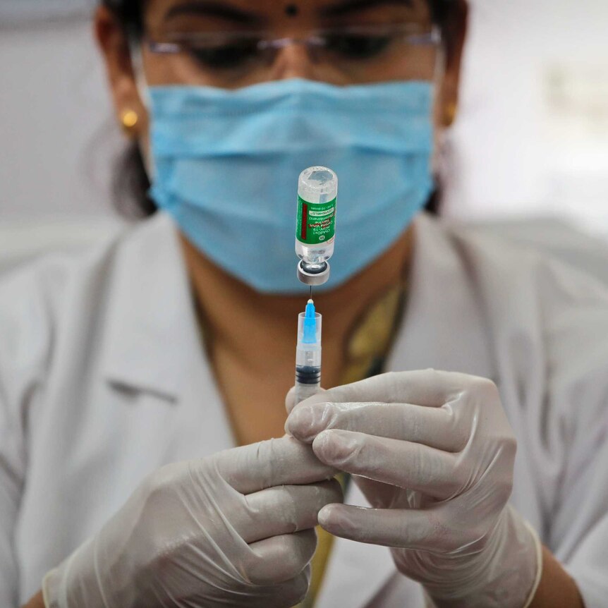 A health worker prepares to administer a COVID-19 vaccine at a hospital.