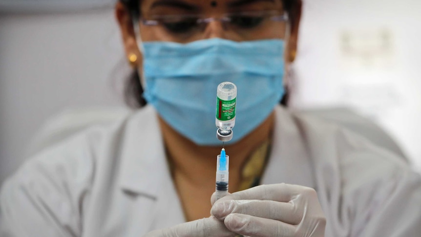 A health worker prepares to administer a COVID-19 vaccine at a hospital.