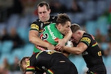 Isaah Yeo and the Panthers wrestle with Cameron Murray of South Sydney in a tackle.