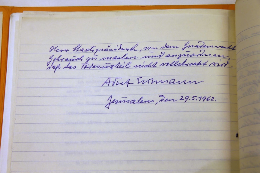 A yellowed pieced of lined paper with several lines of German writing in blue ballpoint pen.