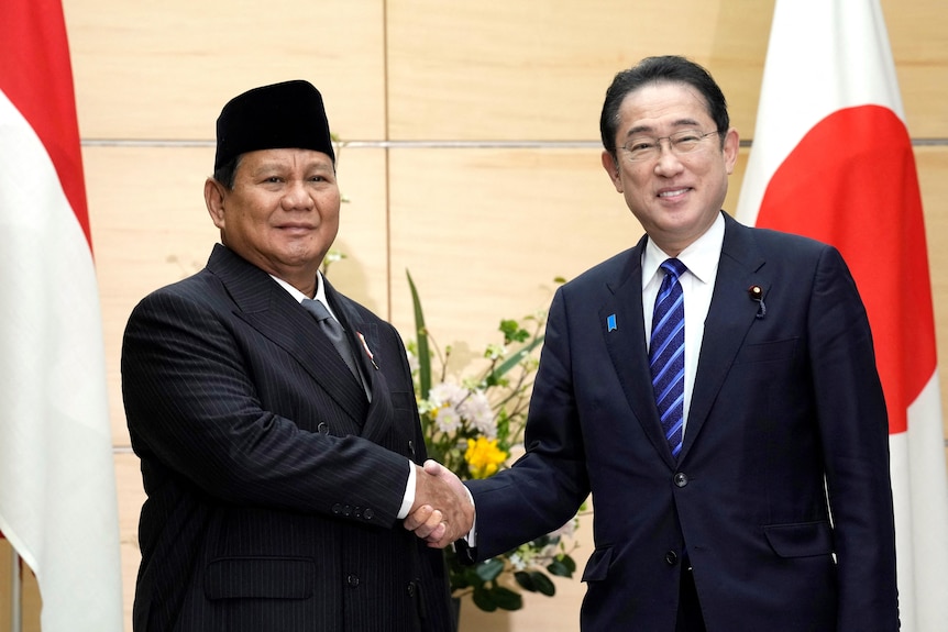 Indonesian president-elect Prabowo Subianto  and Japan's Prime Minister Fumio Kishida shake hands.