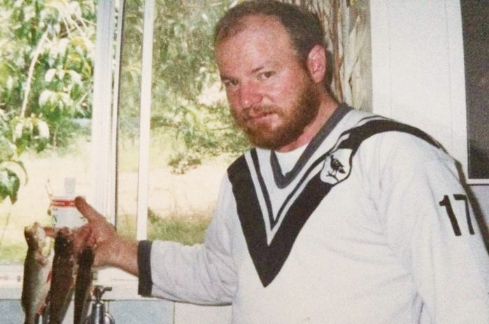 David Wilson in a white top holding three fish.