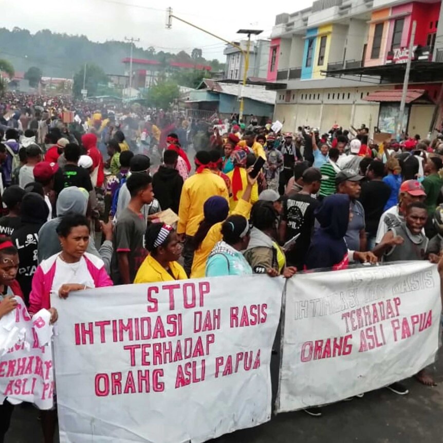 People display banners that read "Stop intimidation and racism towards indigenous Papuans" during a protest in Manokwari.
