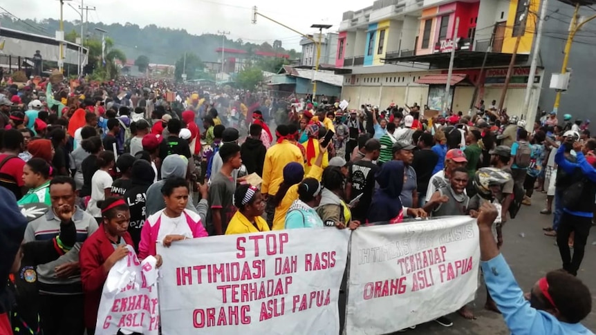 People display banners that read "Stop intimidation and racism towards indigenous Papuans" during a protest in Manokwari.