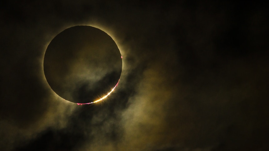A photograph of a total solar eclipse - the moon is skirted by a ring of bright light, that of the Sun