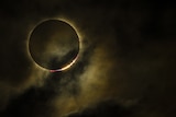 A photograph of a total solar eclipse - the moon is skirted by a ring of bright light, that of the Sun