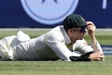 Australia's Steve Smith lays on the ground after dropping a catch