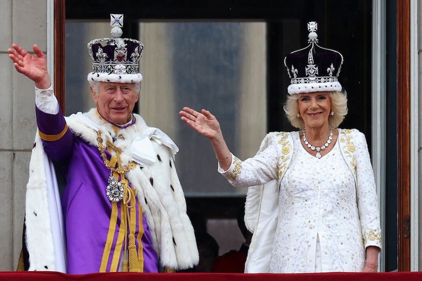 King Charles and Queen Camilla waving wearing crowns.